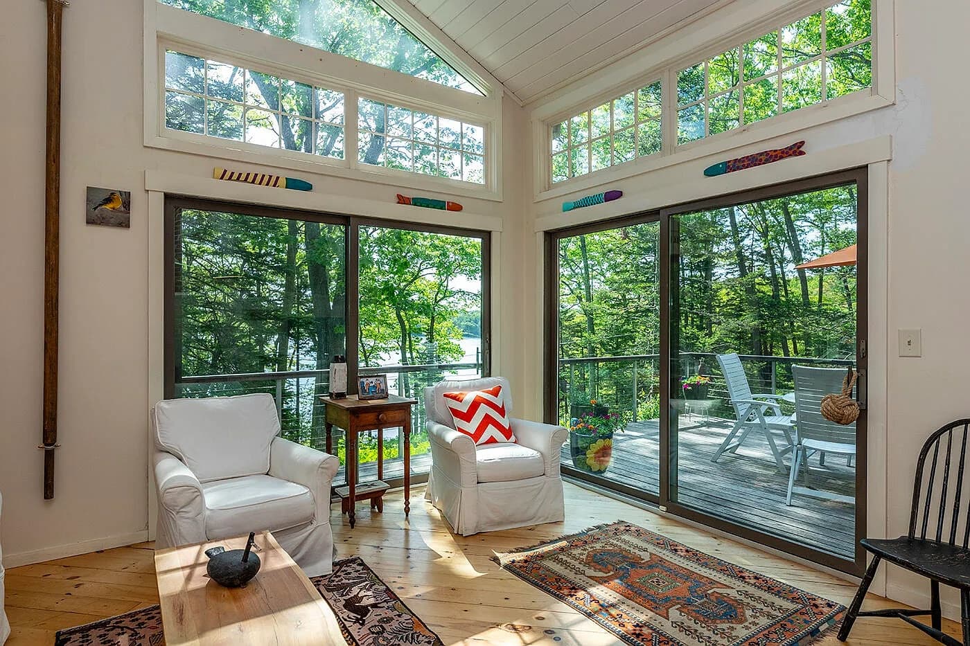 Sun-filled sitting room with tall windows and water views