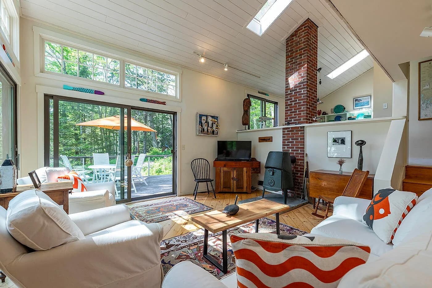 Living room with wood stove and white sofas
